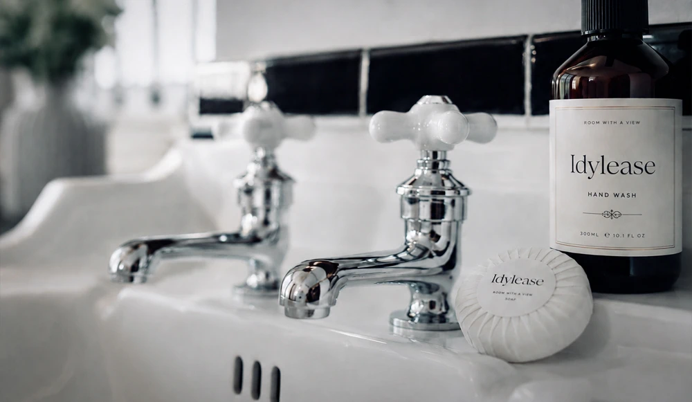Idylease bathroom sink with vintage-style chrome taps, branded hand wash, and guest soap